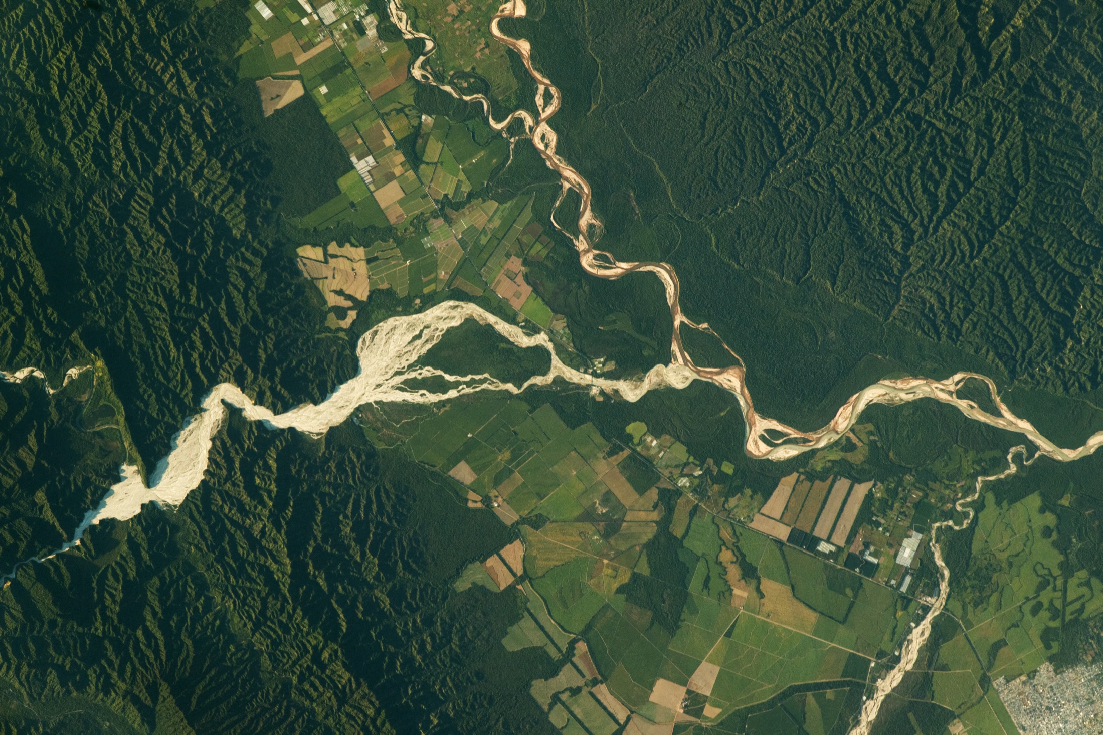 Astronaut photograph of branching rivers winding through forest and foothill valleys in northern Argentina.